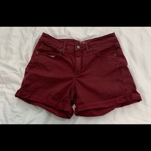 Maroon, mid-length, cuffed shorts.